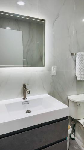 a white bathroom with a sink and a mirror at Line&Light