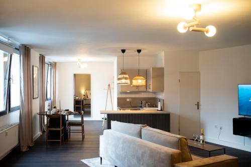 a living room and kitchen with a couch and a table at Zentrale Altstadtwohnung mit privatem Saunabereich in Bielefeld