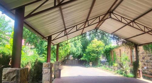 a large wooden pavilion with a walkway at The Journey GuestHouse in Ladybrand