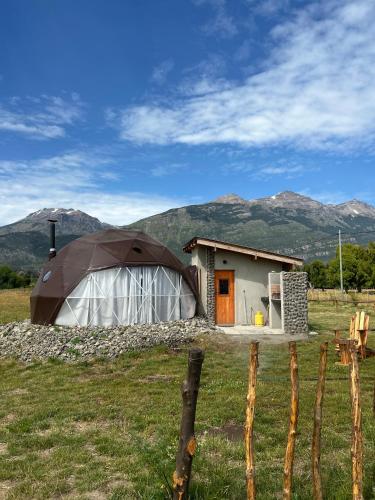 a small house with a tent in a field at Nomade Patagonia Glamping & Domos in Trevelin