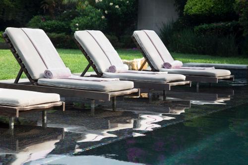 four chairs are lined up next to a pool at Hotel Boutique Casa Fernanda in Tepoztlán