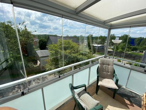 a balcony with two chairs and large windows at Spacious and charming villa close Gothenburg in Kållered