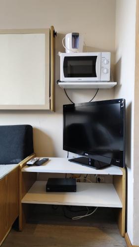 a desk with a television and a microwave on it at Apartment in Las Leñas in Las Lenas
