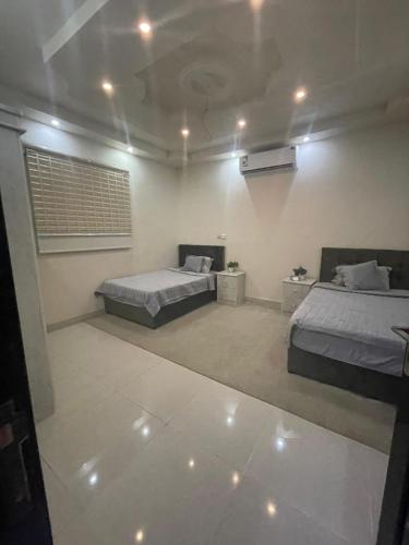 a bedroom with two beds and a wall at وحدات طيبة in Medina