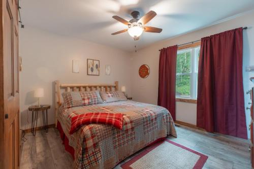 une chambre avec un lit et un ventilateur de plafond dans l'établissement Amazing View Hot Tub Firepit BBQ Private Pets, à Rileyville