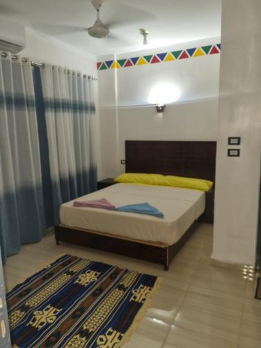 a bedroom with a bed with a colorful banner above it at ABAZIDO Nubian Guest House in Aswan