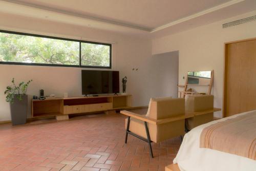 a bedroom with a bed and a flat screen tv at Hotel Boutique Casa Fernanda in Tepoztlán
