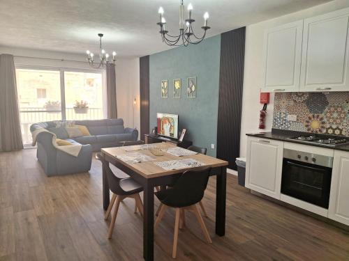 a kitchen and living room with a table and a couch at Cherry Blossom Apt Courtyard-5min Walk to Centre in Victoria