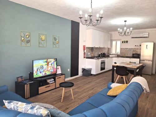a living room with a blue couch and a kitchen at Cherry Blossom Apt Courtyard-5min Walk to Centre in Victoria