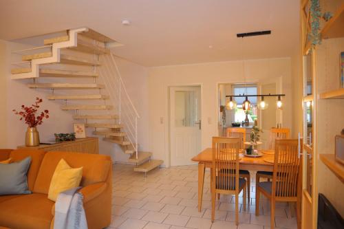 - un salon avec un escalier, une table et des chaises dans l'établissement Ferienhaus De lüttje Mööv, à Dorum Neufeld