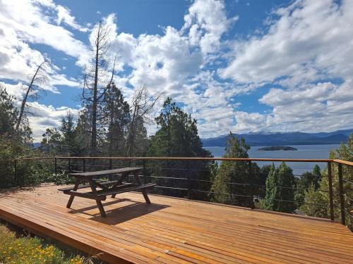 a wooden deck with a picnic table on top at Padornelo Sur in San Carlos de Bariloche