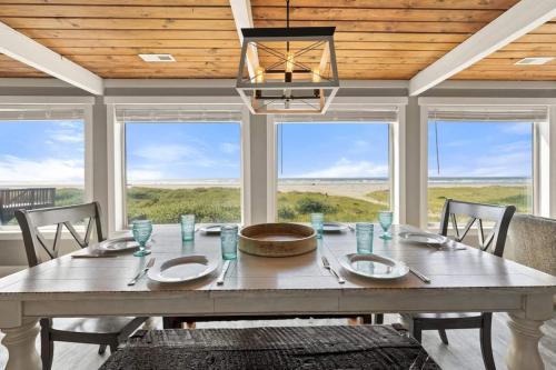 a dining room with a large table and windows at Tide Pool Town Home, Entire House, Amazing Views! in Moclips