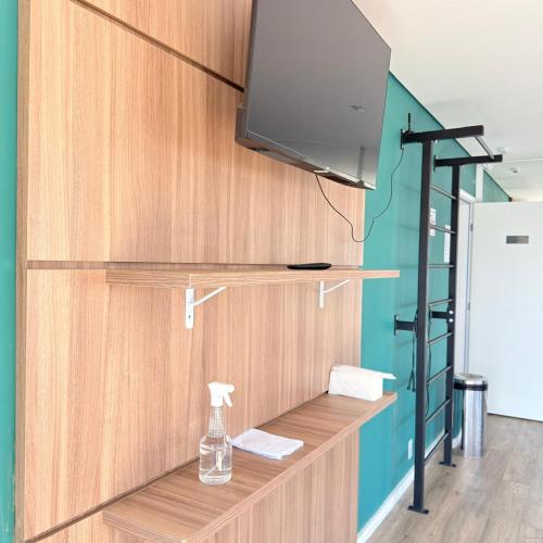 półka z telewizorem i butelką na niej w obiekcie 103NV Studio Liberdade SP 300 m Estação Liberdade acomoda ate 03 pessoas w São Paulo