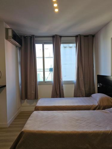 a bedroom with two beds and a large window at Tempora 621 in Buenos Aires