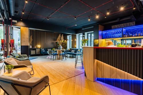 a restaurant with a bar with chairs and tables at Villa Verdi Pleasure & Spa in Łeba