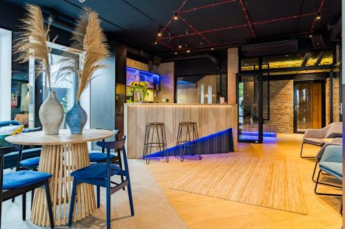 a lobby with a table and chairs and a bar at Villa Verdi Pleasure & Spa in Łeba