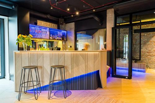 a bar in a restaurant with two stools at Villa Verdi Pleasure & Spa in Łeba
