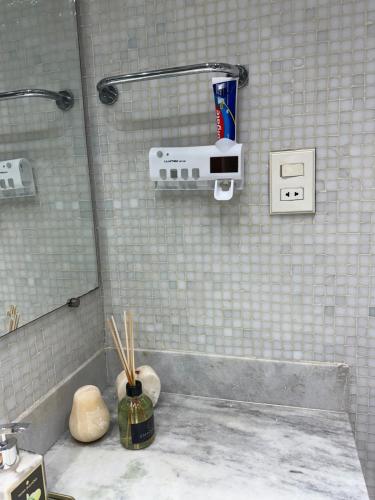 a white tiled bathroom with a shower with chopsticks at Hospede-se em Alphaville flat moderno com lazer in Barueri