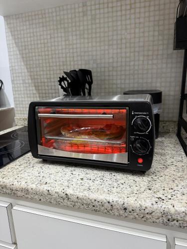a toaster oven sitting on top of a counter at Hospede-se em Alphaville flat moderno com lazer in Barueri