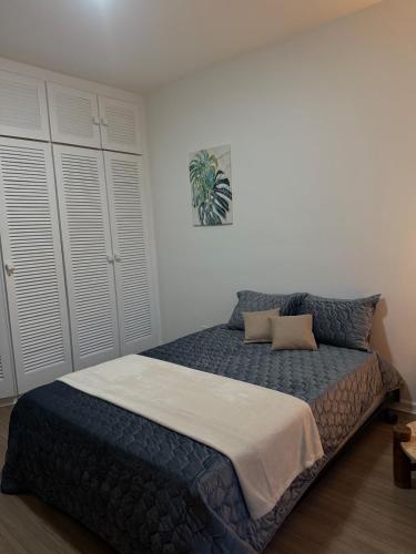 a bed in a bedroom with white walls and white cabinets at Hospede-se em Alphaville flat moderno com lazer in Barueri