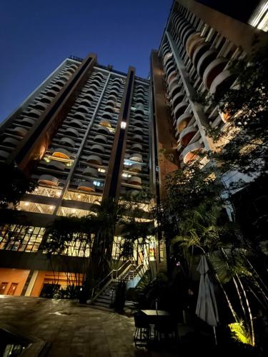 a tall apartment building with a patio in front of it at Hospede-se em Alphaville flat moderno com lazer in Barueri