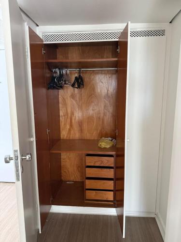 a walk in closet with a wooden cabinet and a door at Hospede-se em Alphaville flat moderno com lazer in Barueri