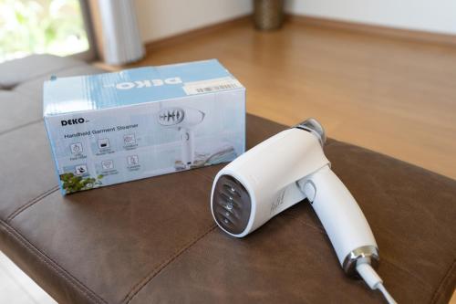 a white electric hair dryer next to a box at Minatogawa Stay OKINAWA in Yaese