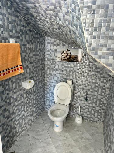 a bathroom with a toilet in a tiled wall at Balance Surf Morocco , Quality rooms , Moroccan food , Activities in Aourir