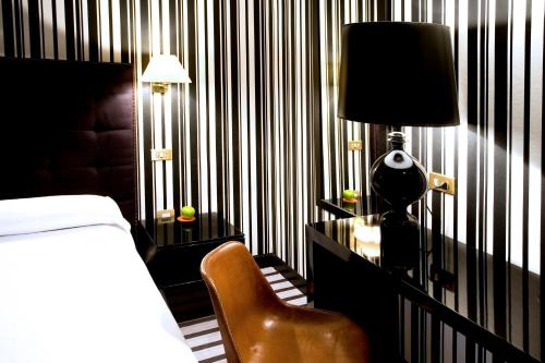 1 dormitorio con 1 cama y escritorio con lámpara y silla en Hotel Clarin, en Oviedo