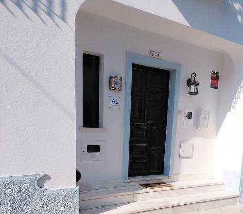 a black door on the side of a white building at Villa Sesta in Vila de Frades
