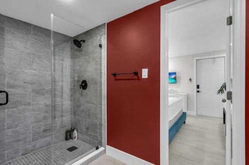 a bathroom with a shower with a red wall at La Pergola Villa 7 Br Poolhot Tub Location in Miami