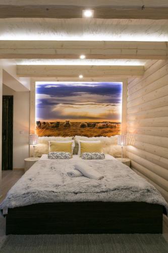 a bedroom with a large bed with a painting on the wall at VIP Apartamenty Stara Polana 2 in Zakopane