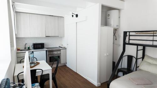 ポルトにあるBonfim Residenceの小さなテーブルとベッドのある小さな白いキッチン