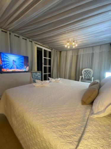 a large white bed in a room with a tv at Valle Suites, la Mejor Ubicación in Valledupar