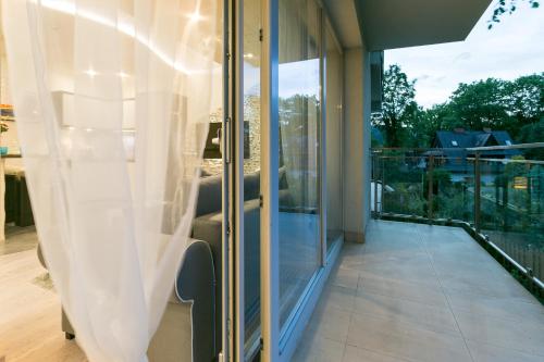 a room with glass doors and a balcony at VIP Apartamenty Stara Polana 2 in Zakopane