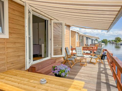 a wooden deck with a table and chairs on the water at Fuut 24-26 in Nieuwersluis