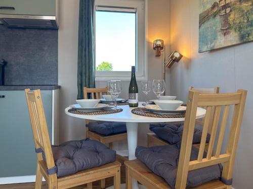 a dining room table with chairs and a bottle of wine at Fuut 24-26 in Nieuwersluis