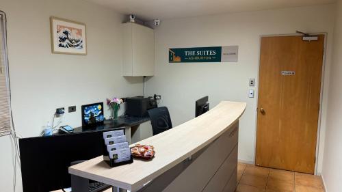 an office with a desk and a sign on the wall at The Suites Ashburton in Ashburton