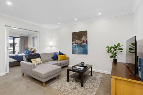 a living room with a couch and a tv at 309 Secret City Sanctuary PrkingPoolView in Perth