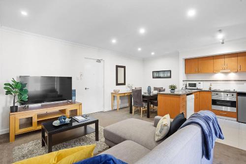 a living room with a couch and a kitchen at 309 Secret City Sanctuary PrkingPoolView in Perth