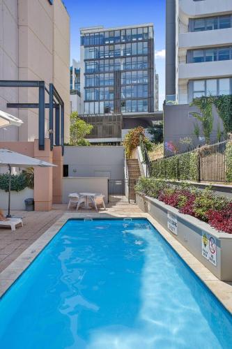 a large blue swimming pool on top of a building at 309 Secret City Sanctuary PrkingPoolView in Perth
