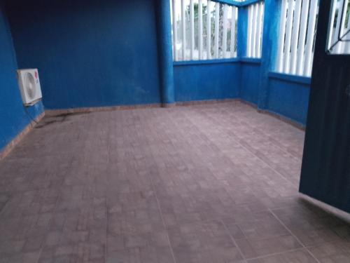 an empty room with blue walls and a tile floor at casa playa eden coveñas in Coveñas