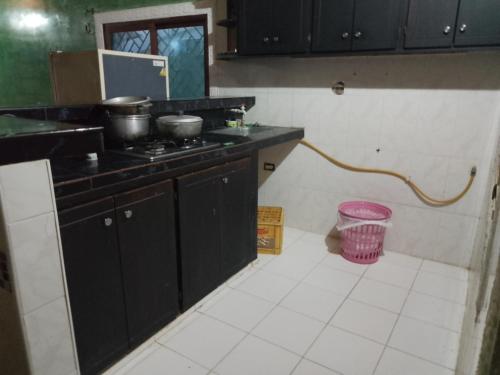 a kitchen with a stove and a pink trash can at casa playa eden coveñas in Coveñas