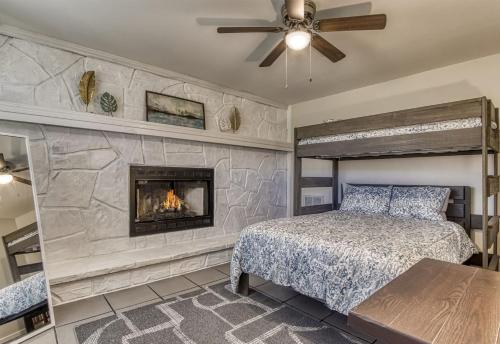 een slaapkamer met een stenen muur en een open haard bij Absolutely Gorgeous, Modern Retreat W Hot Tub in Sevierville