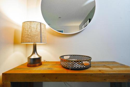 a table with a lamp and a mirror on it at Rivetstays - The Atmos I in Toronto