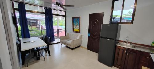 a kitchen with a refrigerator and a table and a chair at Ballena Rey Hotel in Uvita