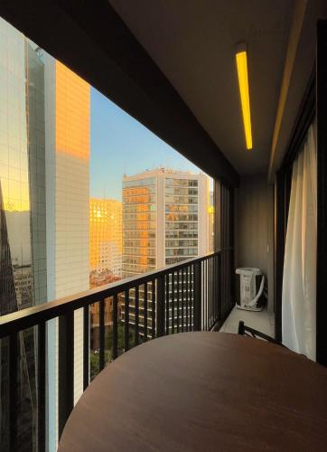 a balcony with a table and a view of a city at Skylux Studios de Luxo in Rio de Janeiro
