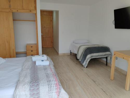 a bedroom with two beds and a flat screen tv at Hospedaje La Angostura in Ica