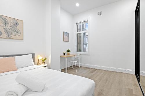 a white bedroom with a bed and a desk at Cozy Double Room in Kensington - Walk to UNSW Easy CBD Access -External and Shared Kitchen or Bathroom Access in Sydney