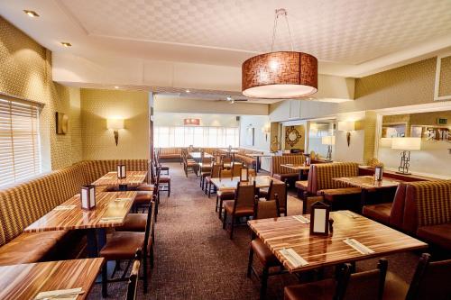 a dining room with wooden tables and chairs at Abbotsford Hotel in Dumbarton